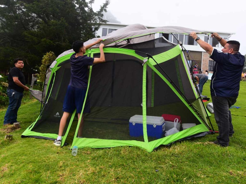Visitantes arman sus tiendas de campaña en la zona de camping de El Pital, un área amplia rodeada de neblina y vegetación. elsalvador.com