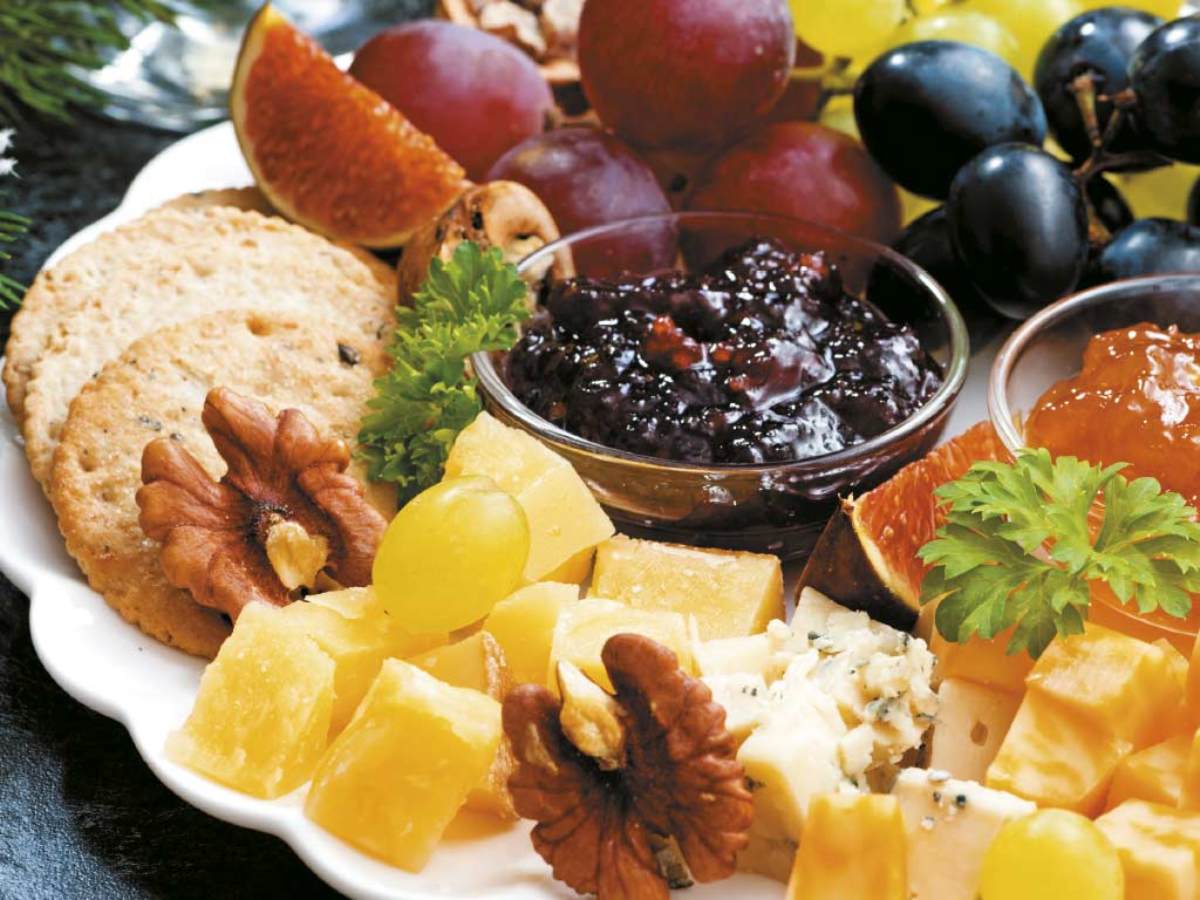 Una tabla de quesos con frutas, nueces y mermeladas es perfecta para recibir a tus invitados con estilo y sabor en cualquier celebración de fin de año.