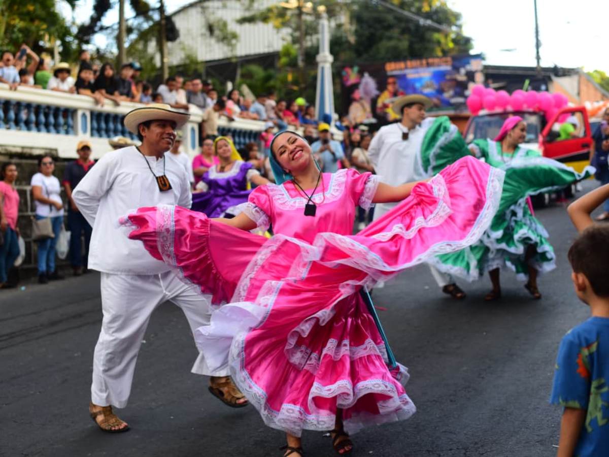 Bailarines llenan de color y folclor las calles de Cojutepeque durante el desfile típico, resaltando la identidad cultural en honor a la Reina de la Caña de Azúcar.