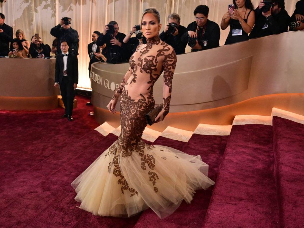 Jennifer Lopez fiel a su estilo, eligió un vestido ajustado con transparencias y bajo de tul de Jean-Louis Scherrer, acompañado por moño italiano y maquillaje que destacó la mirada.
