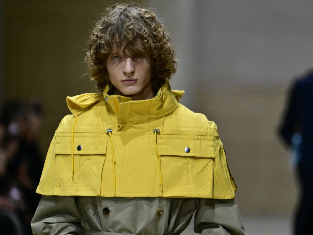 Un modelo presenta un look técnico de **Prada** en la Semana de la Moda Masculina de Milán Otoño-Invierno 2026-2027, con énfasis en funcionalidad y sobriedad contemporánea.