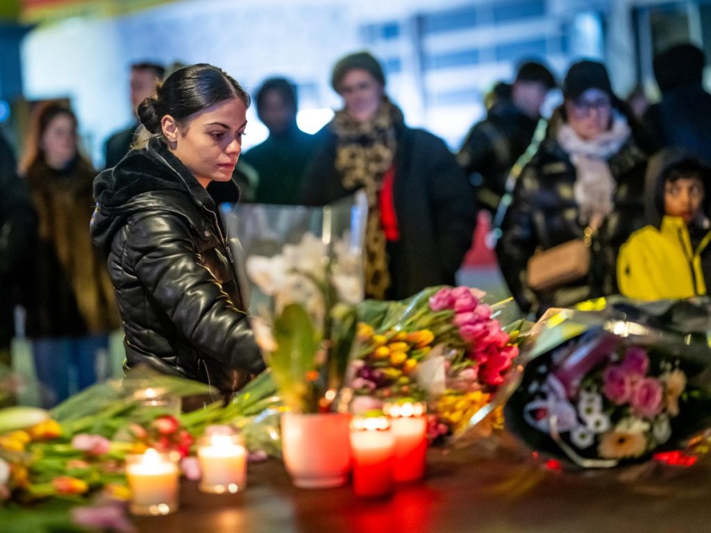 Una mujer coloca flores cerca del lugar donde un incendio arrasó un bar lleno de gente durante las celebraciones de Nochevieja en la ciudad de esquí alpino de Crans-Montana el 1 de enero de 2026. Foto AFP