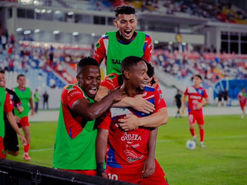 El festejo del colombiano-salvadoreño Christian Gil (abajo) con sus compañeros de Firpo, tras anotarle a Alianza FC. / Foto X de Firpo