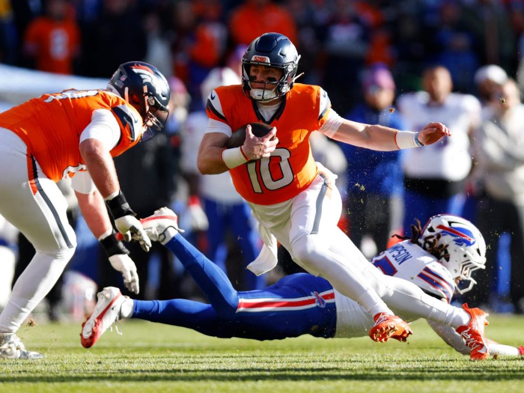 Bo Nix, número 10 de los Denver Broncos, corre para conseguir el primer down contra los Buffalo Bills durante el primer cuarto de la ronda divisional de la AFC en el Empower Field At Mile High el 17 de enero de 2026 en Denver, Colorado. AFP