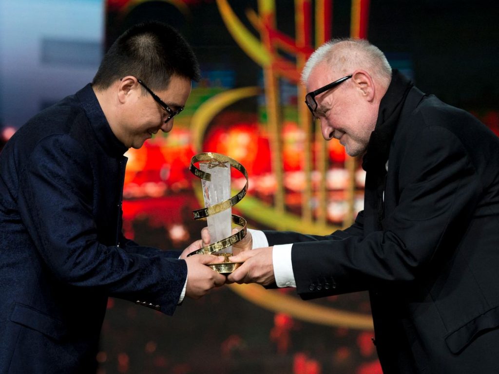 El director chino Zang Qi Wu (izq.) recibe su premio del director húngaro Bela Tarr durante la ceremonia de premios de la 14ª edición del Festival Internacional de Cine de Marrakech, el 10 de diciembre de 2016 en Marrakech.