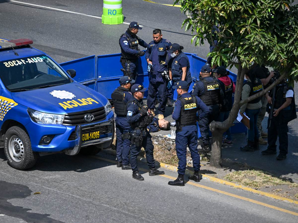 Fiscales del Ministerio Público recaban evidencia en la escena del crimen donde un agente de policía fue asesinado por presuntos pandilleros en el sector Castañas, de Villa Nueva, Guatemala, el 18 de enero de 2025. Fotografía/ AFP