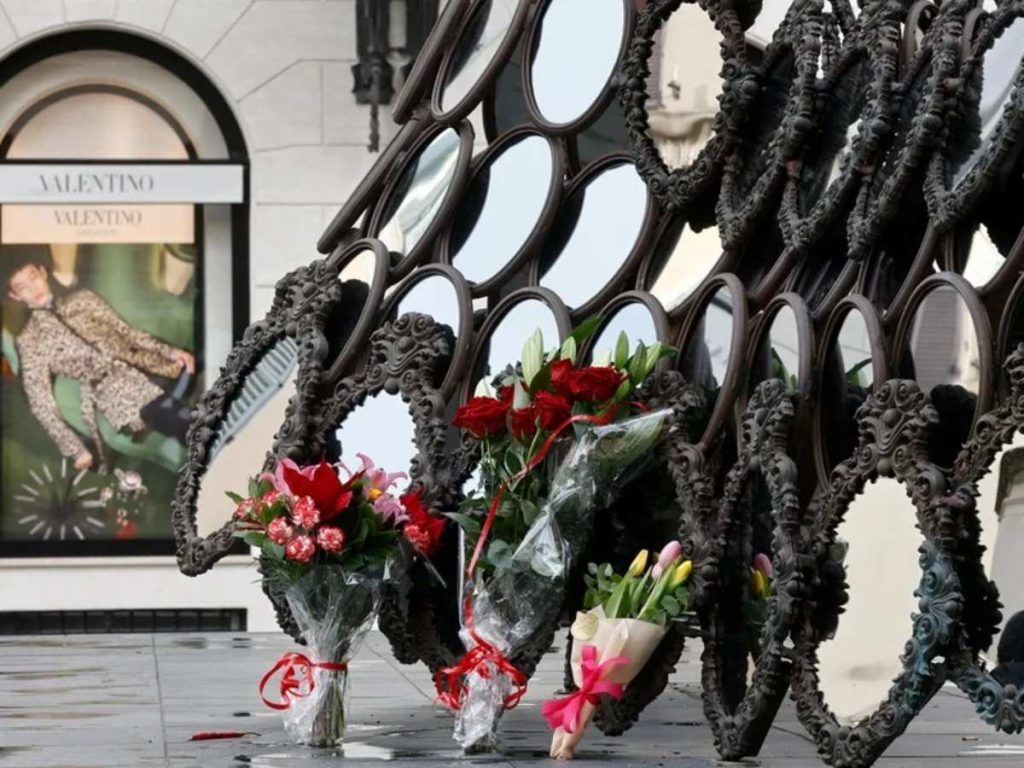La máscara 'Ill Be Your Mirror' de la artista portuguesa Joana Vasconcelos, regalada a Valentino Garavani por el artista, rodeada hoy de ramos de flores en su memoria. EFE/EPA/Vincenzo Livieri