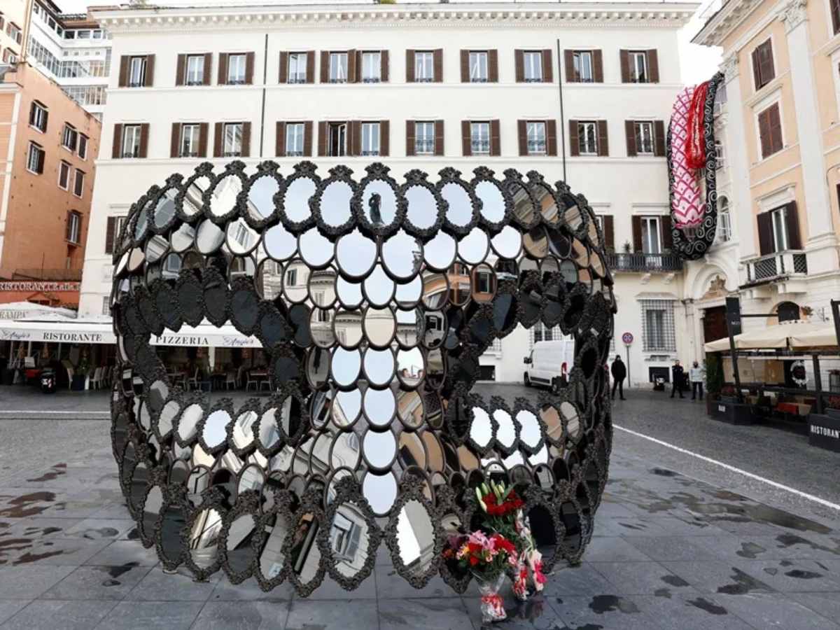 La máscara ‘Ill Be Your Mirror’ de la artista portuguesa Joana Vasconcelos, regalada a Valentino Garavani por el artista, rodeada hoy de ramos de flores en su memoria.