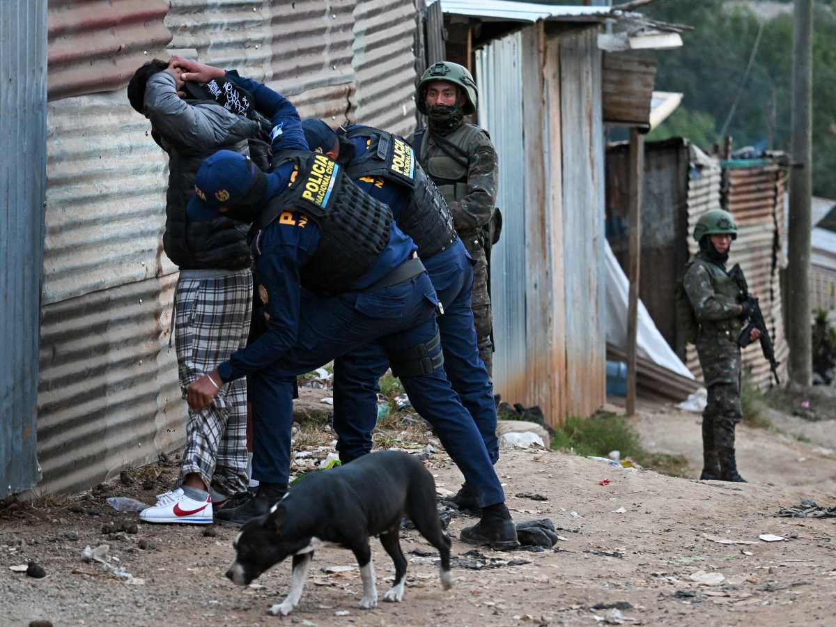 Policías guatemaltecos registran a dos hombres en una calle del barrio Nueva Jerusalén durante el estado de emergencia declarado por el gobierno en la Ciudad de Guatemala el 20 de enero de 2026.