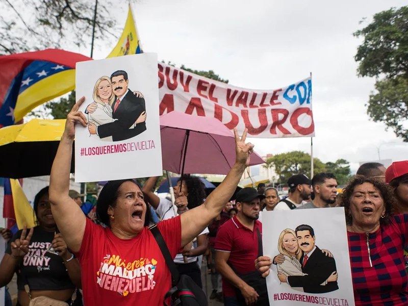 Un grupo de personas sostiene carteles de Nicolás Maduro y su esposa durante una manifestación este sábado, en Caracas (Venezuela).