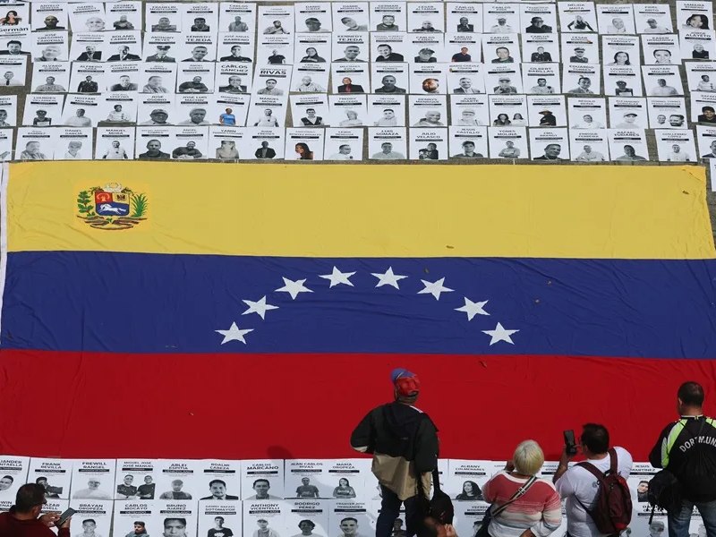 Personas organizan carteles con imágenes de presos políticos, en la Plaza del Rectorado UCV, en Caracas (Venezuela).