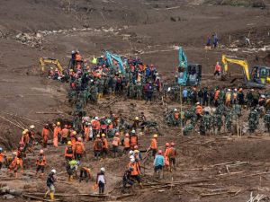 Rescatistas y voluntarios operan bajo condiciones climáticas adversas en la zona golpeada por el deslizamiento de tierra.