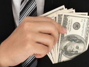 Business man Displaying a Spread of Dollar