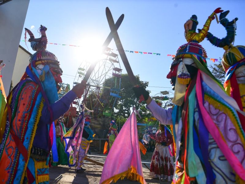 Danzantes con máscaras coloridas ejecutan coreografías ancestrales durante las fiestas patronales.