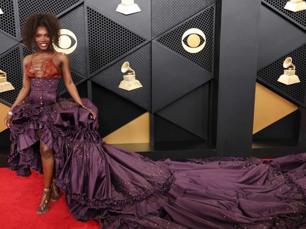 Doechii apuesta por una silueta estructurada en tonos profundos, donde el corset y la cola convierten el movimiento en parte clave del look.