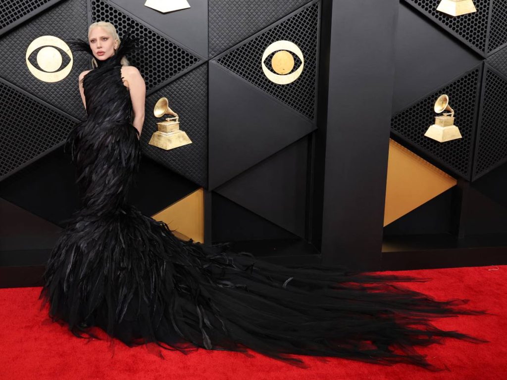 Lady Gaga impacta en la alfombra roja con un vestido negro de plumas de fuerte dramatismo, reafirmando su lugar como ícono de la moda performática.