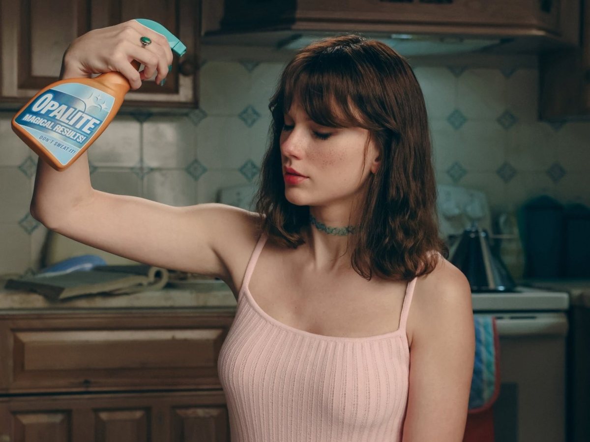 El producto ficticio Opalite aparece como símbolo visual central, reforzando la metáfora de transformación personal dentro de una cocina de aire nostálgico.