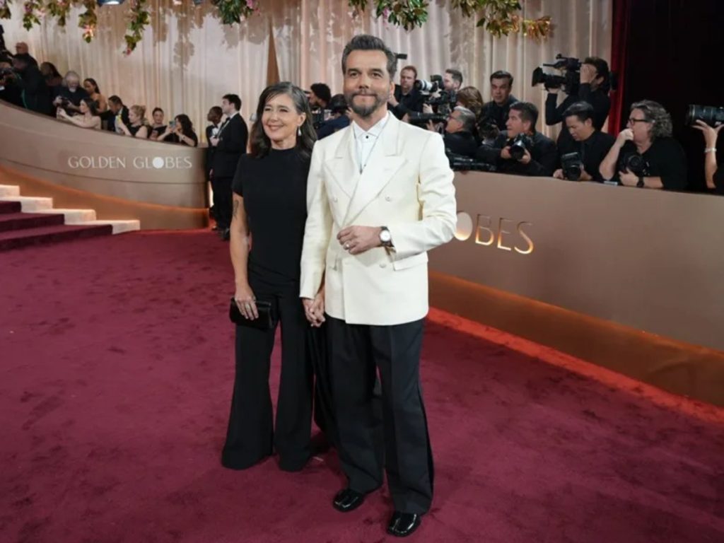 El actor brasileño Warner Moura y Germaine Le en los Globos de Oro; él apuesta por esmoquin cruzado en tono crudo, una versión luminosa y actual de la etiqueta clásica.