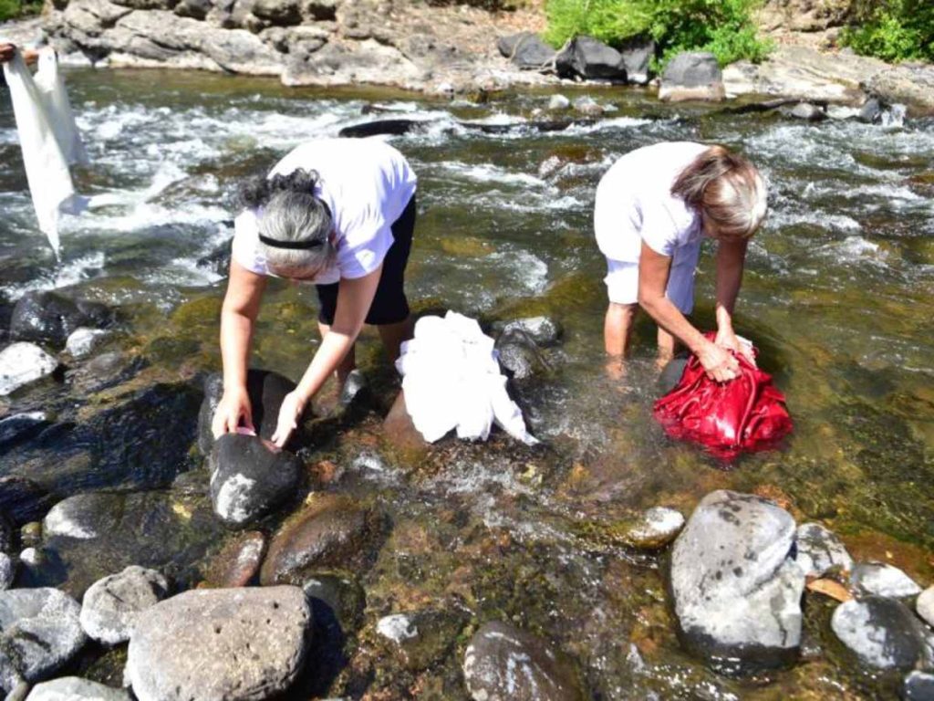 Mujeres de Cacaopera, en Morazán, lavan en el río Torola la ropa de las imágenes de santos y vírgenes, como parte de una tradición transmitida por generaciones.