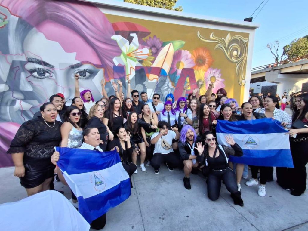 Turistas nicaragüenses posan frente al mural de Shakira en las afueras del Estadio Mágico González, previo al cuarto concierto de la artista en El Salvador.