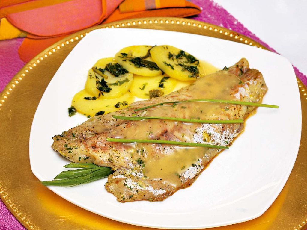 La curvina al horno con salsa de limón y hierbas es una preparación que realza el sabor natural del pescado con notas cítricas y hierbas frescas. 