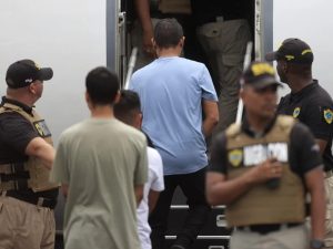 Fotografía de archivo de personas subiendo a un avión mientras son custodiadas por integrantes del Servicio Nacional de Migración de Panamá.