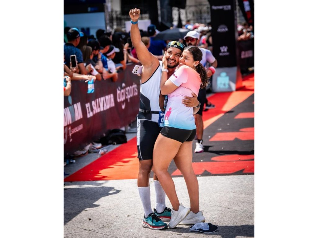 Daniel Gutiérrez y Anita Monterrosa se abrazan emocionados tras la propuesta de matrimonio, justo después de cruzar la meta del IRONMAN 70.3 San Salvador en el Centro Histórico de San Salvador. Fotografía/ Secretaria de Prensa del Gobierno de El Salvador