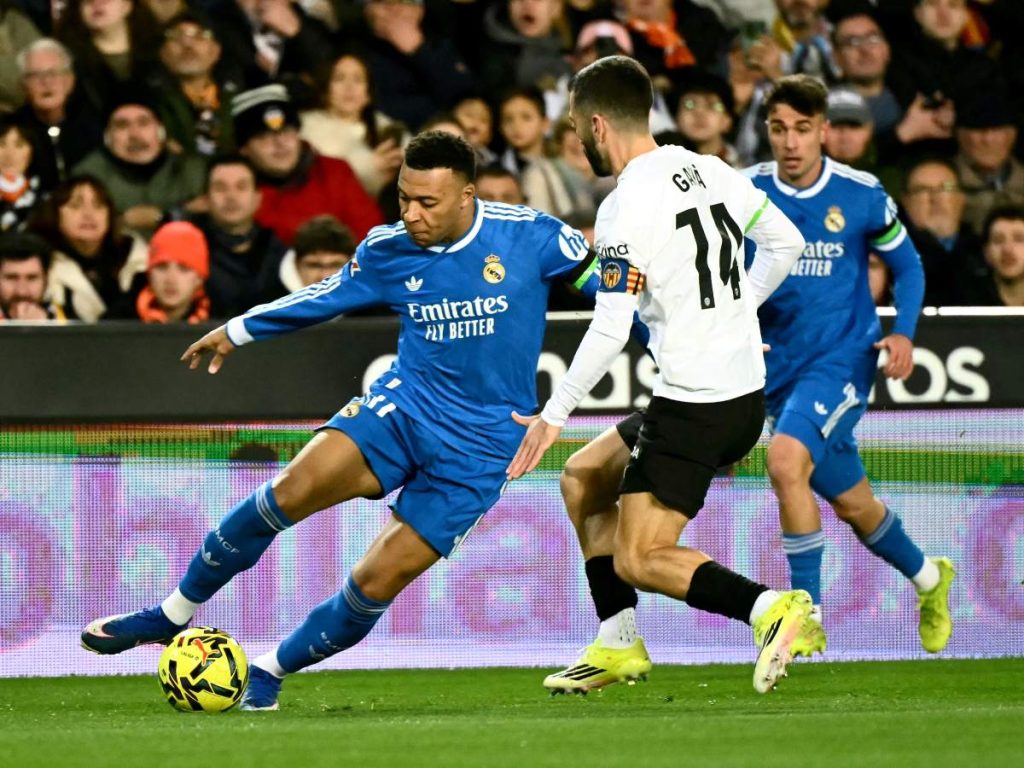 El delantero francés #10 del Real Madrid, Kylian Mbappé, lucha por el balón con el defensor español #14 del Valencia, José Gaya, durante el partido de fútbol de la liga española entre el Valencia CF y el Real Madrid CF en el Estadio Mestalla en Valencia el 8 de febrero de 2026. Foto AFP