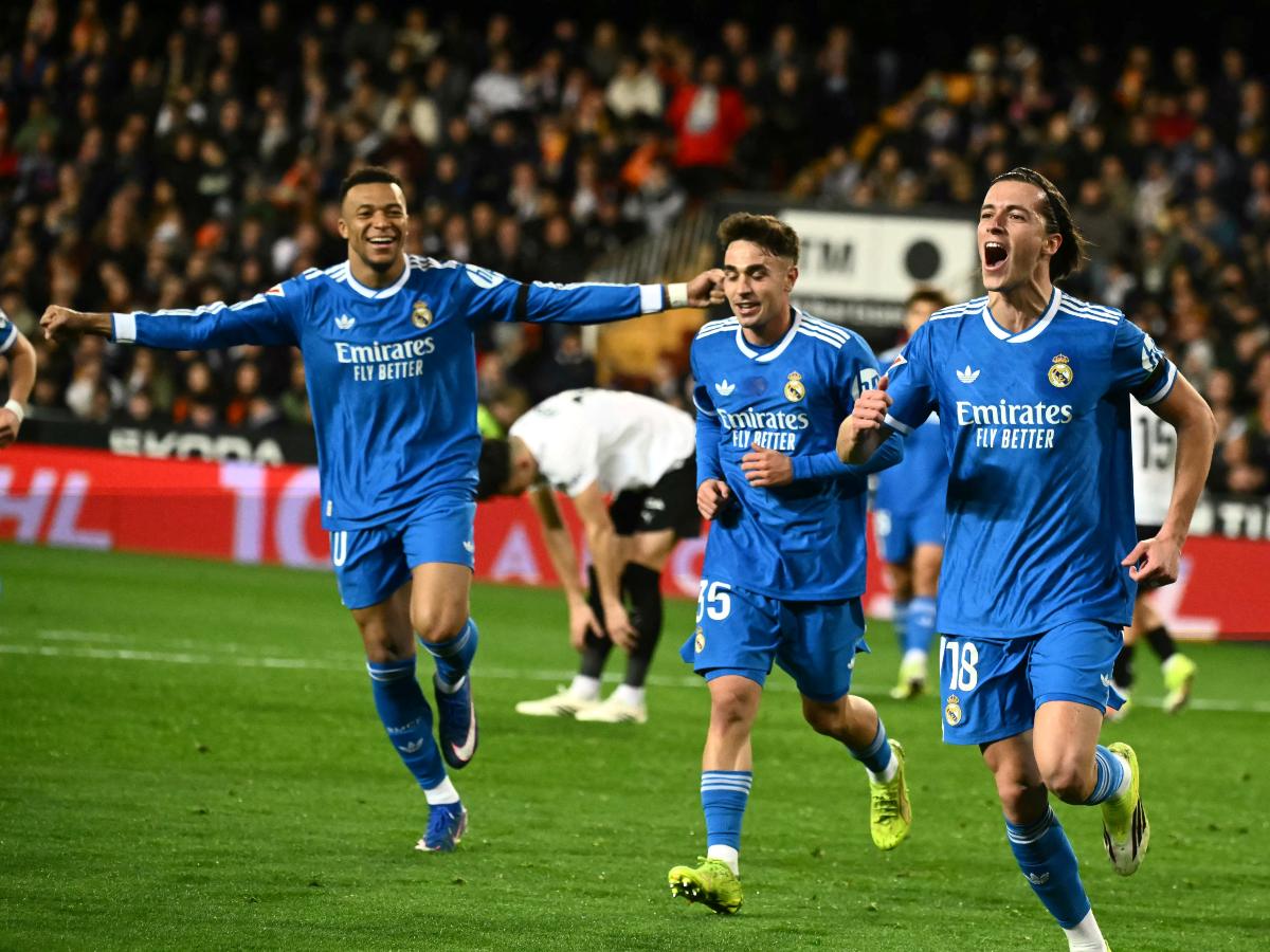El defensa español #18 del Real Madrid, Álvaro Carreras, celebra con el delantero francés #10 del Real Madrid, Kylian Mbappé (izq.), el primer gol de su equipo durante el partido de fútbol de la liga española entre el Valencia CF y el Real Madrid CF en el Estadio Mestalla en Valencia el 8 de febrero de 2026. Foto AFP