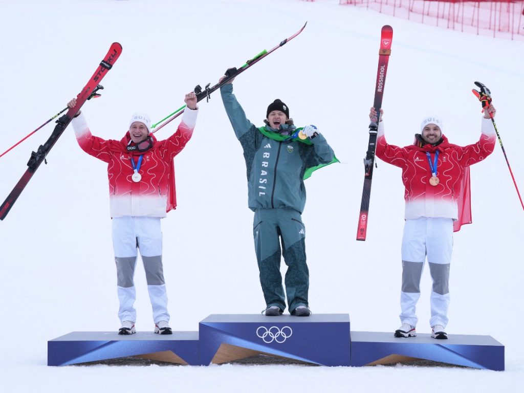 El medallista de oro brasileño Lucas Pinheiro Braathen (C), el medallista de plata suizo Marco Odermatt (I) y el medallista de bronce suizo Loic Meillard (D) posan en el podio del evento de esquí alpino de slalom gigante masculino durante los Juegos Olímpicos de Invierno Milano Cortina 2026 en el Centro de Esquí Stelvio en Bormio (Valtellina) el 14 de febrero de 2026. Foto AFP