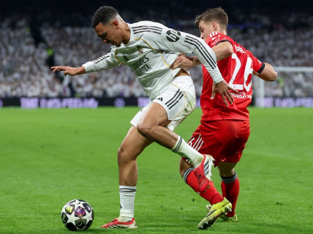 El defensor inglés del Real Madrid, #12 Trent Alexander-Arnold (izq.), es desafiado por el defensor sueco del SL Benfica, #26 Samuel Dahl. Fotografía/ AFP