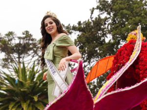 Fátima Bosch saluda al público durante el desfile de la Fiesta de la Fruta y de las Flores en Ambato, antes del incidente que generó preocupación entre asistentes.
