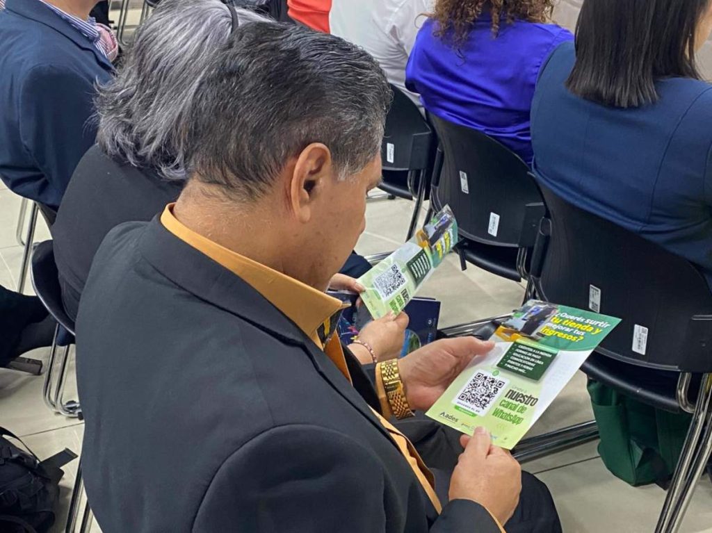 Asistentes revisan material informativo sobre créditos de hasta $10,000 y capacitación para fortalecer capital de trabajo en tiendas de barrio.