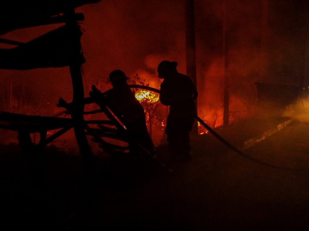 Elementos del Cuerpo de Bomberos trabajan en la extinción del incendio registrado en la 4.ª Avenida Sur y 8.ª Calle Oriente, en San Salvador Centro.