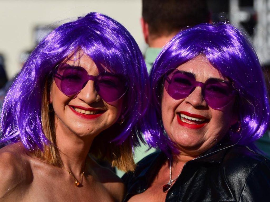 Pelucas moradas y accesorios llamativos destacan entre las asistentes que viven con entusiasmo la previa del concierto de Shakira.