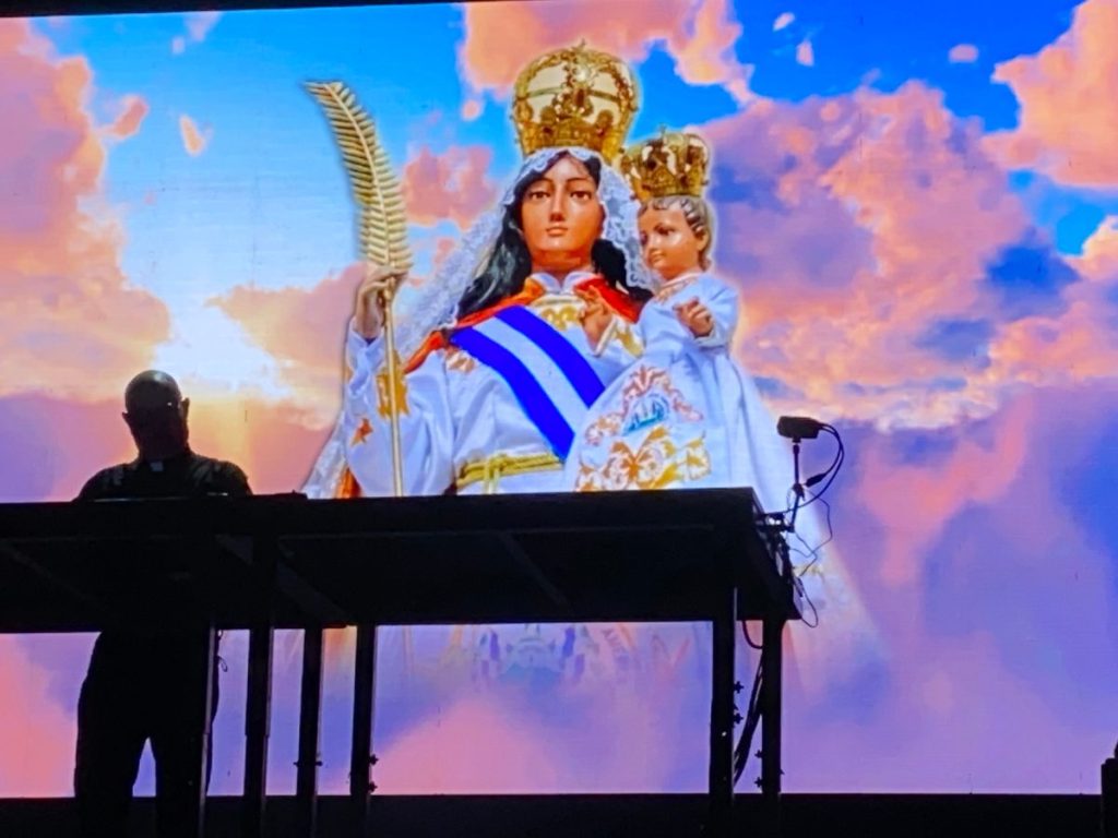 La imagen de la Virgen de la Paz, patrona de El Salvador, acompañó uno de los momentos más simbólicos del espectáculo del sacerdote y DJ Padre Guilherme.