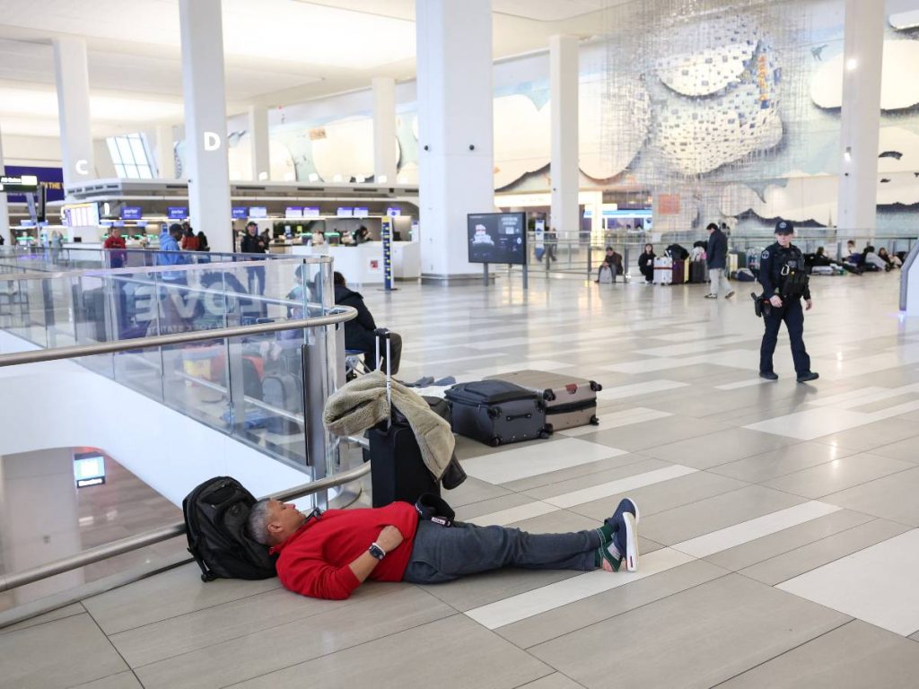 Viajeros esperan en la Terminal B de LaGuardia tras la suspensión de vuelos por el choque entre un avión de Air Canada y un camión de bomberos.