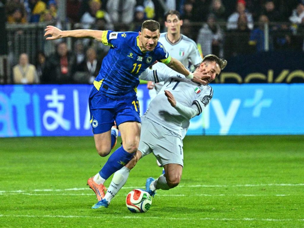 El delantero bosnio-herzegovina número 11, Edin Dzeko (izquierda), lucha por el balón con el delantero italiano número 11, Moise Kean, durante el partido de la final de clasificación europea para la Copa Mundial de la FIFA 2026 entre Bosnia-Herzegovina e Italia en el estadio Bilino-Polje en Zenica el 31 de marzo de 2026. Foto AFP