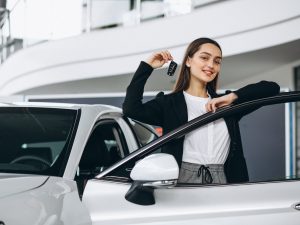 Woman choosing a car in a car showroom