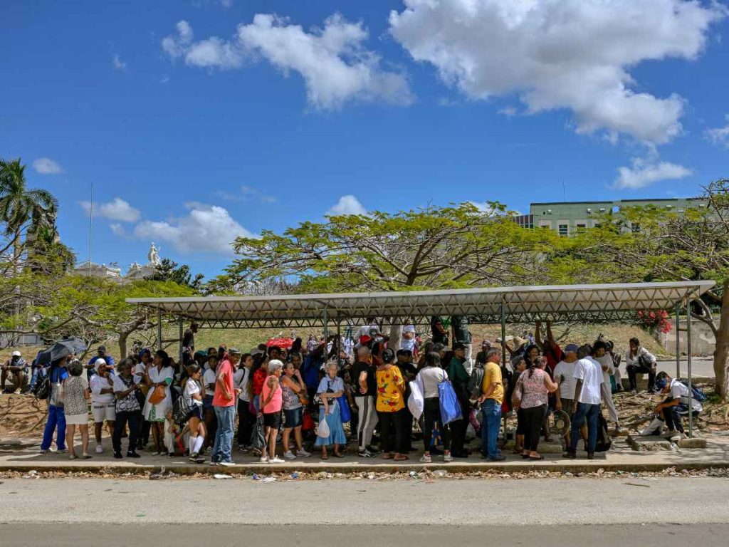 Personas esperan transporte en una parada de autobús durante un apagón en La Habana, el 16 de marzo de 2026, en medio de la crisis energética que afecta a Cuba.
