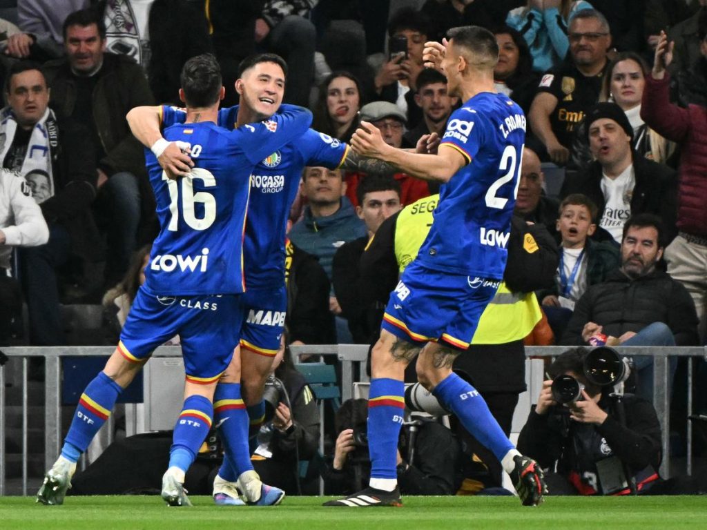 Martín Satriano (medio) celebra su gol con el Getafe ante el Real Madrid. Foto AFP