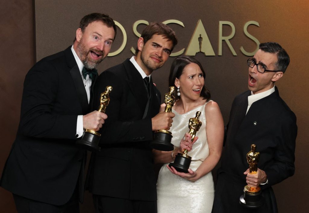 (I/D) Tras un empate en la categoría, los cineastas estadounidenses Jack Piatt y Sam Davis sostienen el Oscar al mejor cortometraje de acción real por "The Singers" junto al cineasta estadounidense Alexandre Singh y la curadora estadounidense Natalie Musteata con su Oscar al mejor cortometraje de acción real por "Two People Exchanging Saliva" en la sala de prensa durante la 98.ª edición de los Premios Óscar en el Dolby Theatre de Hollywood, California, el 15 de marzo de 2026.
(Foto de VALERIE MACON / AFP)
