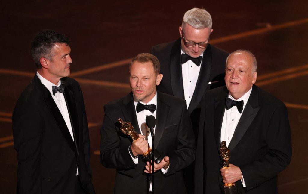 (De izquierda a derecha) El supervisor de efectos visuales estadounidense Eric Saindon, el artista de efectos visuales estadounidense Richard Baneham, Daniel Barrett y el supervisor de efectos visuales estadounidense Joe Letteri reciben el premio a los Mejores Efectos Visuales por "Avatar: Fuego y Ceniza"