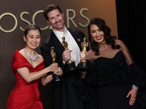 (I/D) La artista y guionista surcoreana-canadiense Maggie Kang, el director de cine estadounidense Chris Appelhans y la productora Michelle Wong posan en la sala de prensa con el Oscar a la Mejor Película de Animación por 