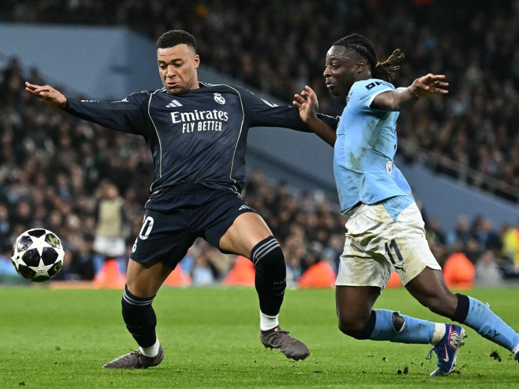 El centrocampista belga del Manchester City, Jeremy Doku (derecha), disputa el balón con el delantero francés del Real Madrid, Kylian Mbappé (izquierda), durante el partido de vuelta de los octavos de final de la Liga de Campeones de la UEFA entre el Manchester City y el Real Madrid en el Etihad Stadium de Manchester, al noroeste de Inglaterra, el 17 de marzo de 2026. (Foto de Paul ELLIS / AFP)