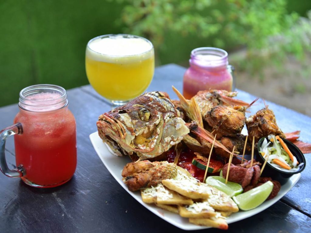 El pescado frito es uno de los platillos más representativos en El Ancla, acompañado de bebidas frescas frente al mar.