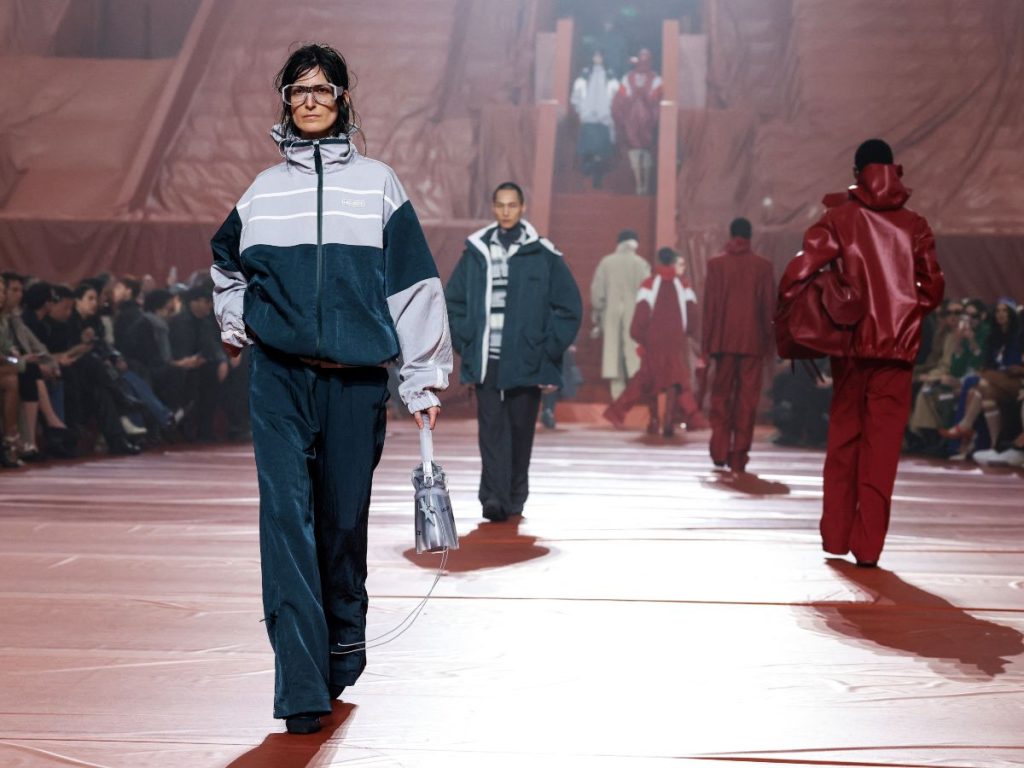 Una modelo luce una sudadera de Lacoste durante la Semana de la Moda de París otoño/invierno 2026-2027, reflejando su evolución hacia el lujo contemporáneo.