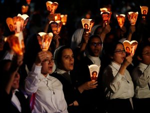Personas sostienen faroles con la imagen de monseñor Óscar Arnulfo Romero durante una peregrinación este sábado, en conmemoración del 46 aniversario de su asesinato en San Salvador (El Salvador).