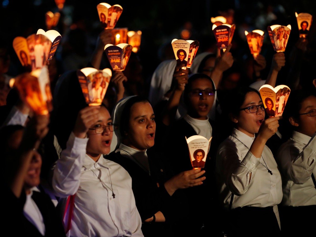 Personas sostienen faroles con la imagen de monseñor Óscar Arnulfo Romero durante una peregrinación este sábado, en conmemoración del 46 aniversario de su asesinato en San Salvador (El Salvador).