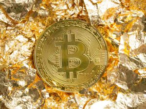 Bitcoin coin on golden foil pieces around decorative background